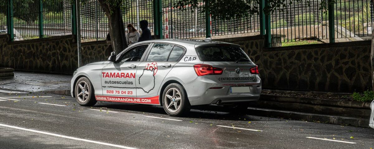 Coche de prácticas de Autoescuelas Tamarán estacionado en la calle, con la rotulación visible del centro