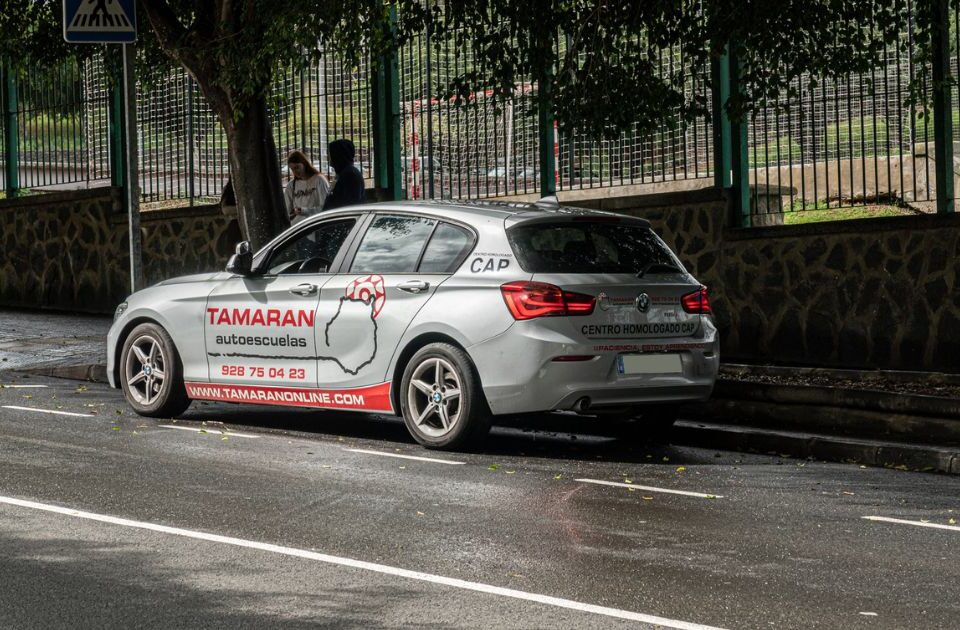 Coche de prácticas de Autoescuelas Tamarán estacionado en la calle, con la rotulación visible del centro