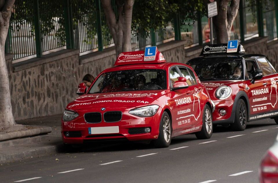 Coches de prácticas de Autoescuelas Tamarán estacionados en la vía durante una clase de conducción