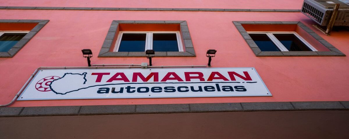 fachada roja con un cartel de tamaran- autoescuela tamaran
