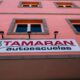 fachada roja con un cartel de tamaran- autoescuela tamaran