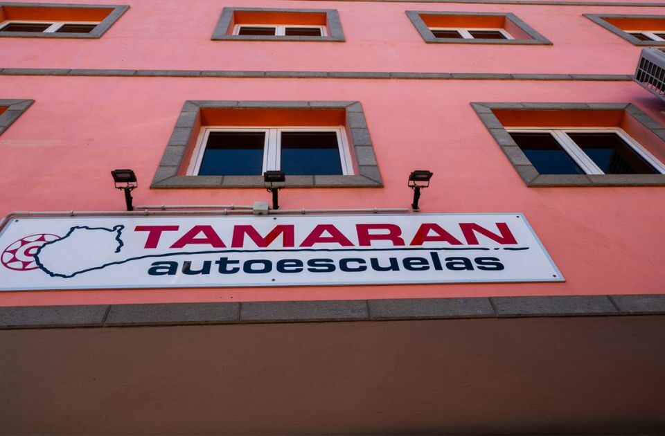 fachada roja con un cartel de tamaran- autoescuela tamaran